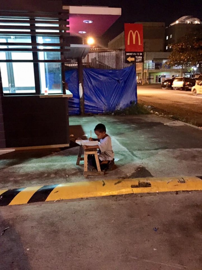 филиппинский мальчик учит уроки на улице