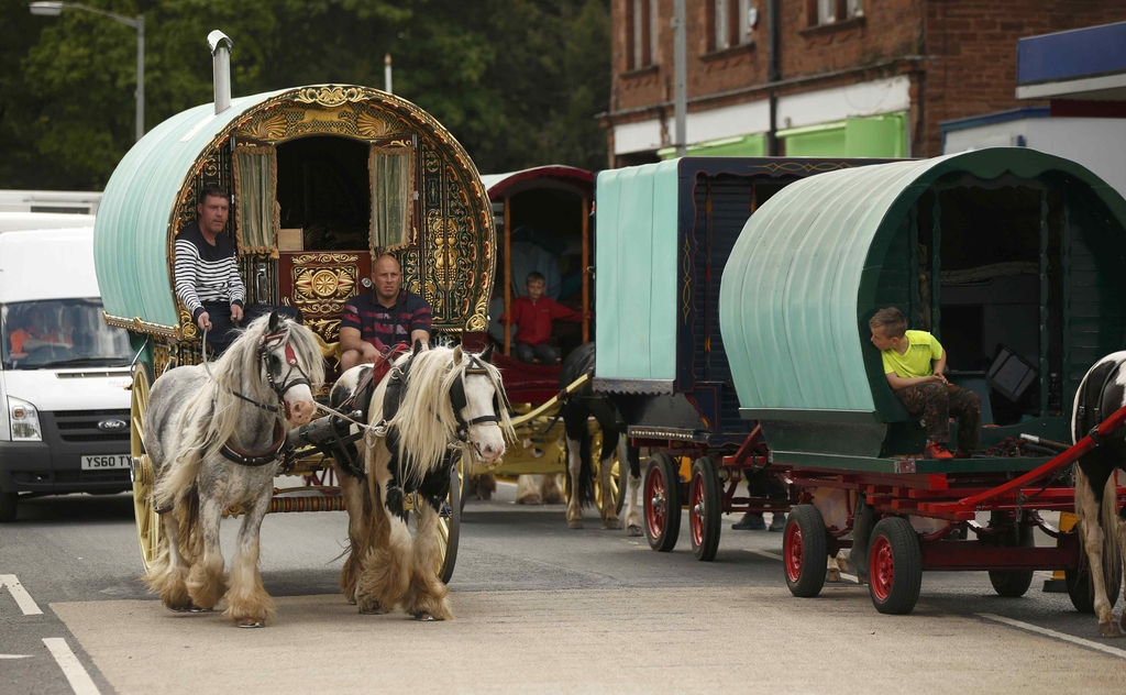 Travellers drive their traditional Romany caravans along the main road in Appleby in Westmorland