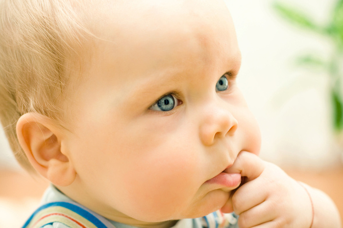 Small cute baby with finger in mouth