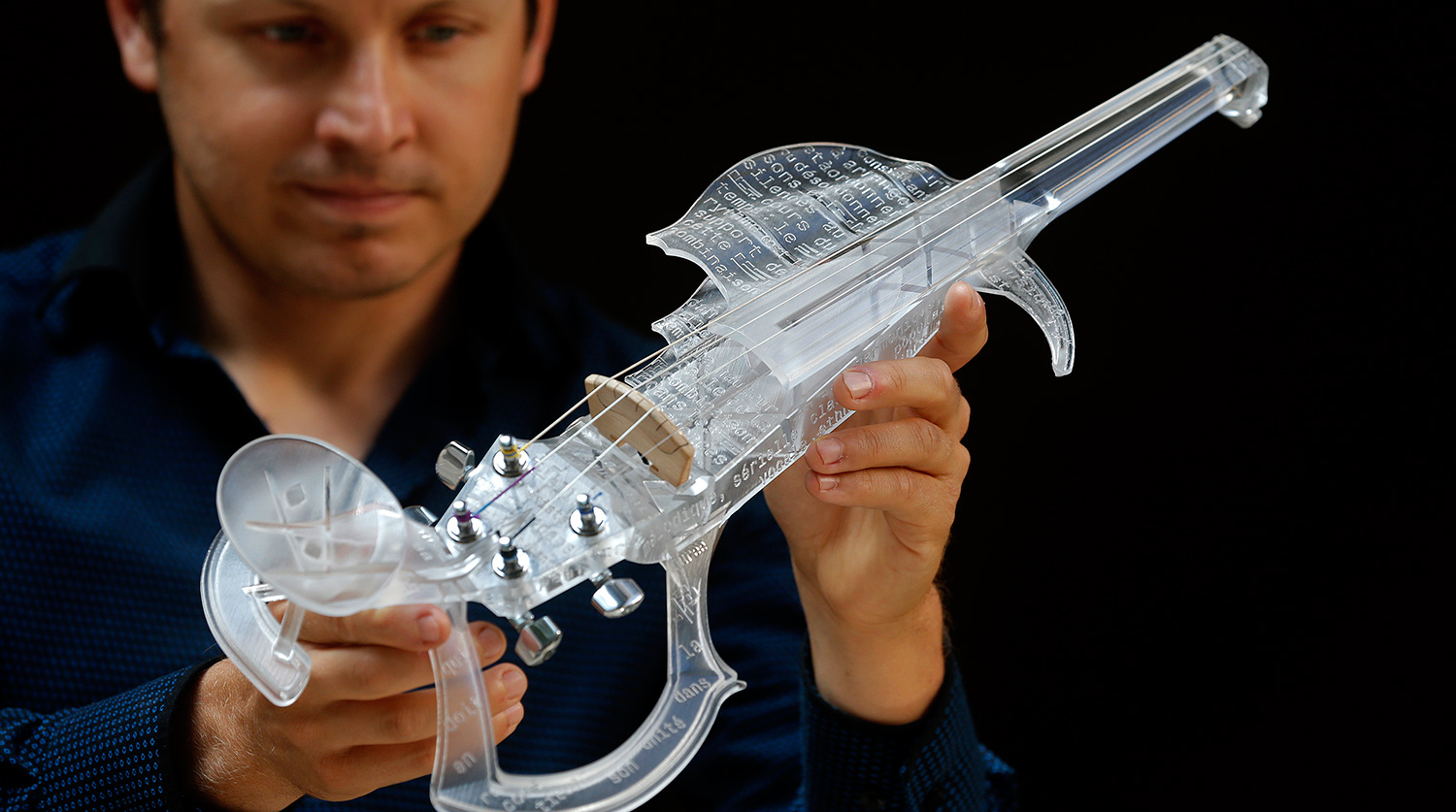 French engineer and professional violinist Laurent Bernadac poses with his 3D printed violin in Paris